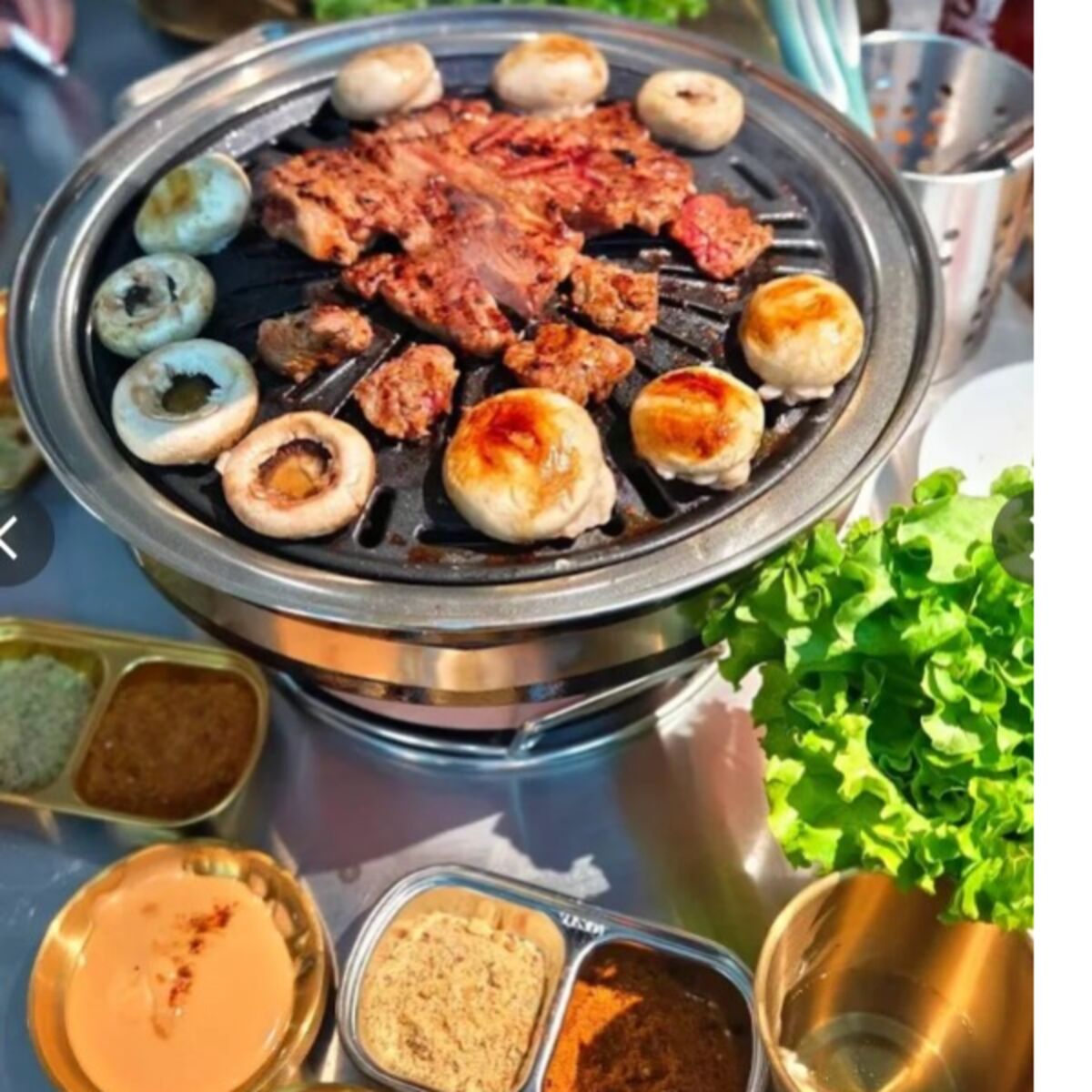 Carne e verdure in cottura sulla griglia al tavolo