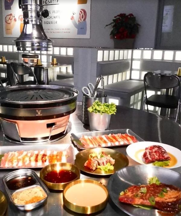 Tavolo apparecchiato con barbecue coreano e selezione di carne